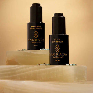  featuring Bakuchiol Night Serum and Gold Day Serum in sleek black bottles with gold branding, displayed on translucent stone slabs against a warm beige backgroung