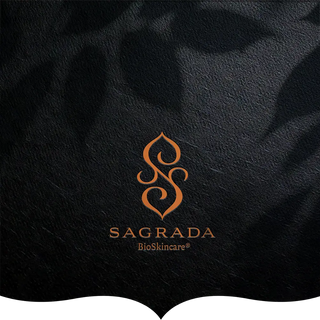 The Sagrada BioSkincare logo in an elegant orange design, displayed on a textured black background with soft shadowed patterns.