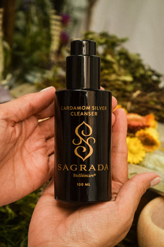 Cleanser Duo featuring Cardamom Silver Cleanser in black bottle held in hands with natural background.