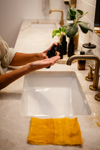 Licensed esthetician Kandi Jo demonstrating a winter skincare ritual with a facial cleanser in a serene, holistic setting—part of Sagrada BioSkincare’s seasonal cleansing masterclass.