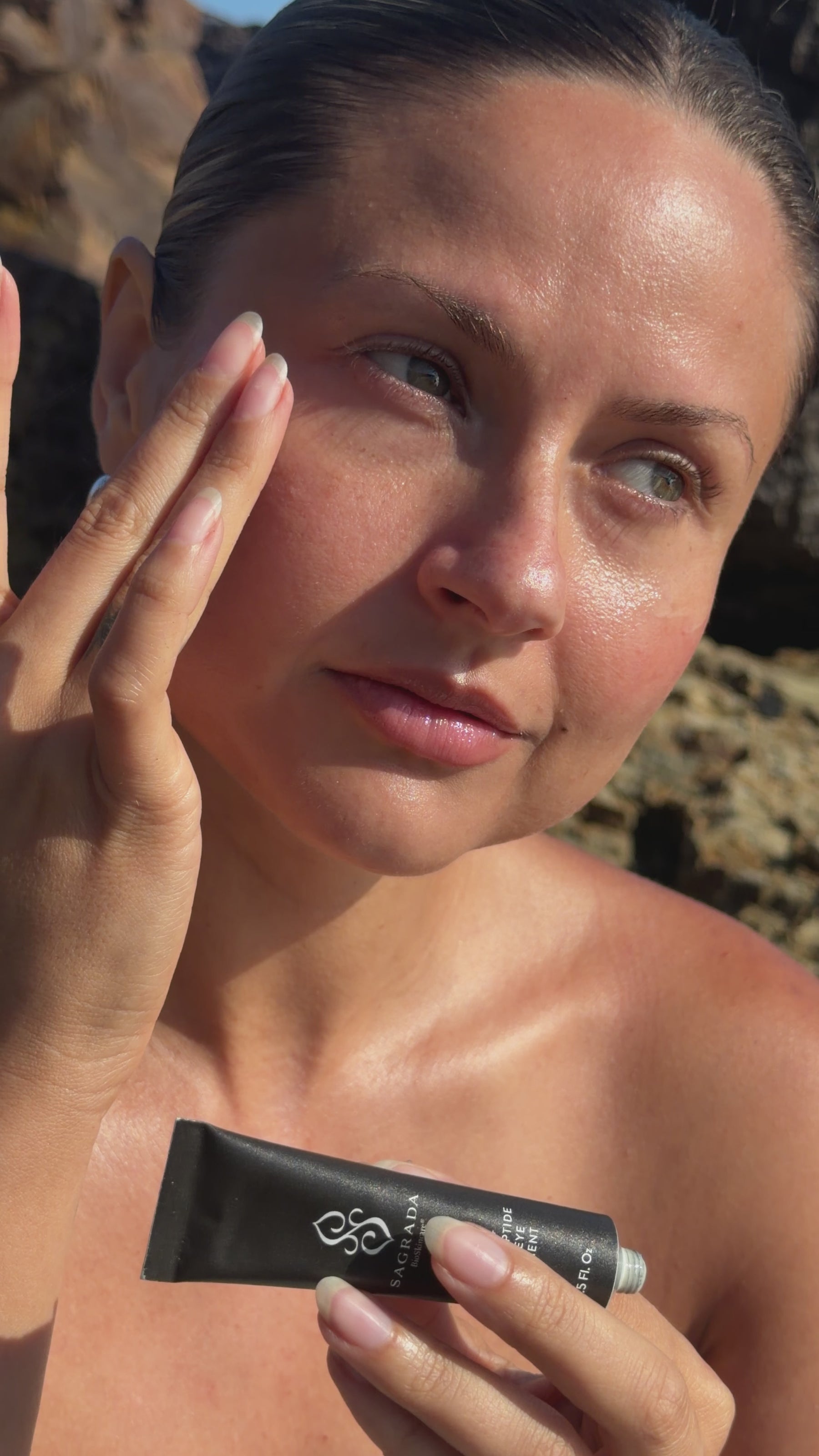 Woman applying Sagrada Neroli + Copper Peptide Under Eye Treatment to visibly hydrate, brighten, and reduce the look of puffiness around the eyes