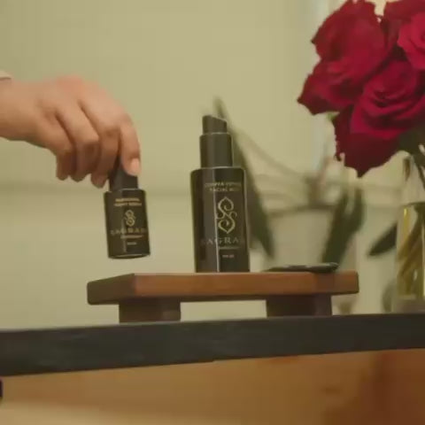 Woman performing her skincare ritual with Sagrada BioSkincare—opening, applying, and massaging product into her face in a calming, intentional sequence