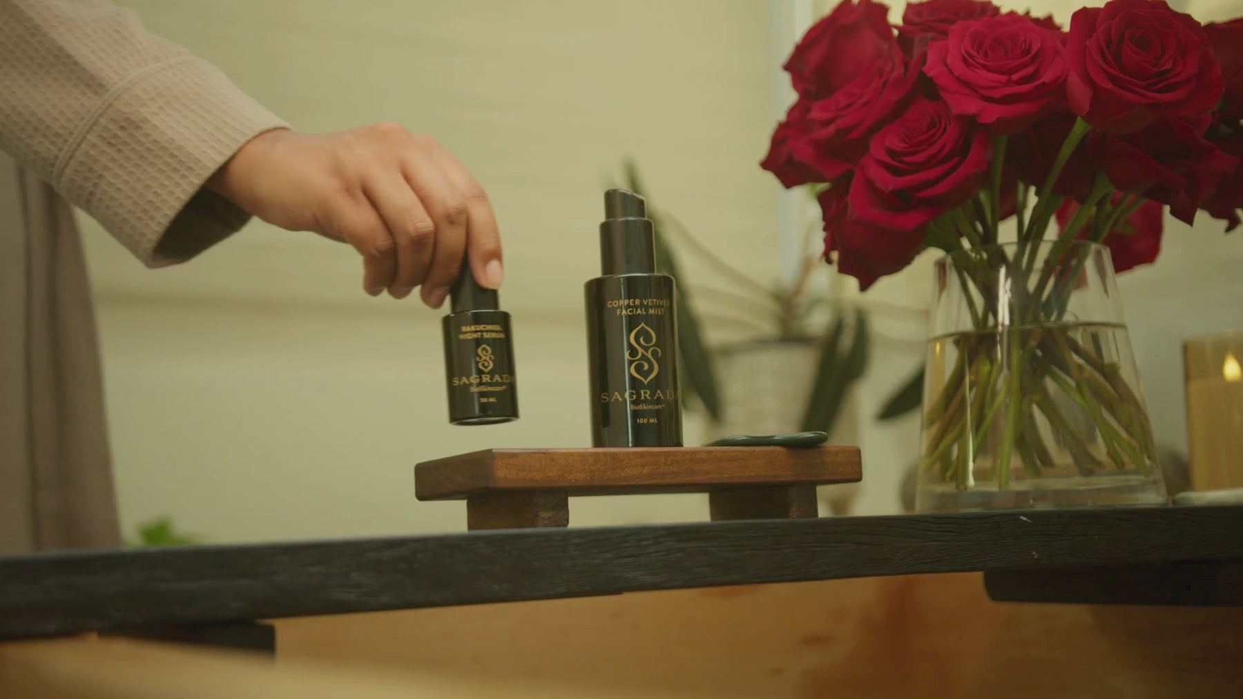 Woman performing her skincare ritual with Sagrada BioSkincare—opening, applying, and massaging product into her face in a calming, intentional sequence
