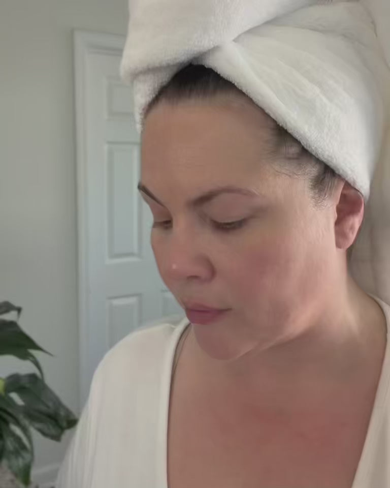 User gently applying Sagrada Licorice Pearl Under Eye Serum under eyes, showcasing texture and smooth roll-on application