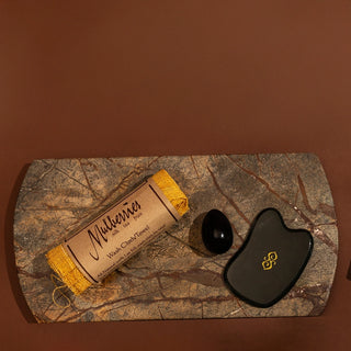 Sagrada beauty tools including raw silk face cloth, obsidian yoni egg, and jade gua sha