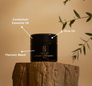 Sagrada Cardamom Silver Cleanser on stone pedestal with labeled ingredients: Cardamom essential oil, olive oil, and plantain weed