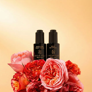 Sagrada Gold Day Serum and Bakuchiol Night Serum displayed among vibrant roses, representing the signature serum collection