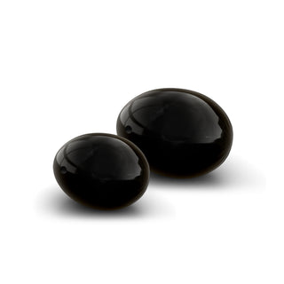 Small and medium-sized black obsidian Yoni eggs on a white background